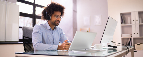 Man listening to a podcast while working on a computer