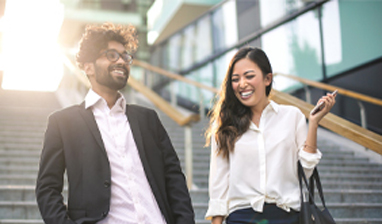 A man and woman smiling while walking down stairs