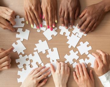 Diverse group of people putting a puzzle together