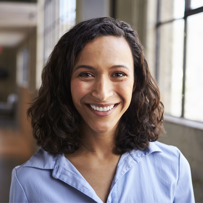 Woman smiling at camera while in naturally lit hallway